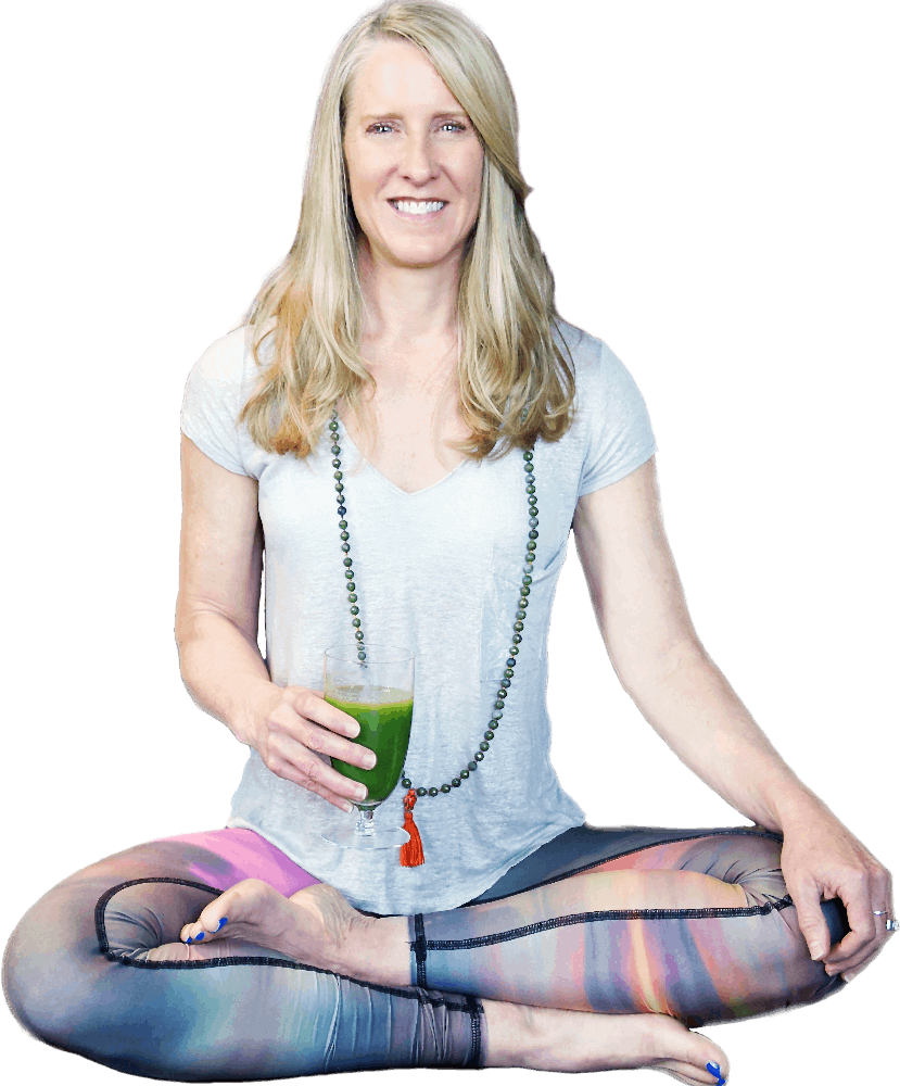 Tanya Mark sitting in the lotus position while holding a smoothie.
