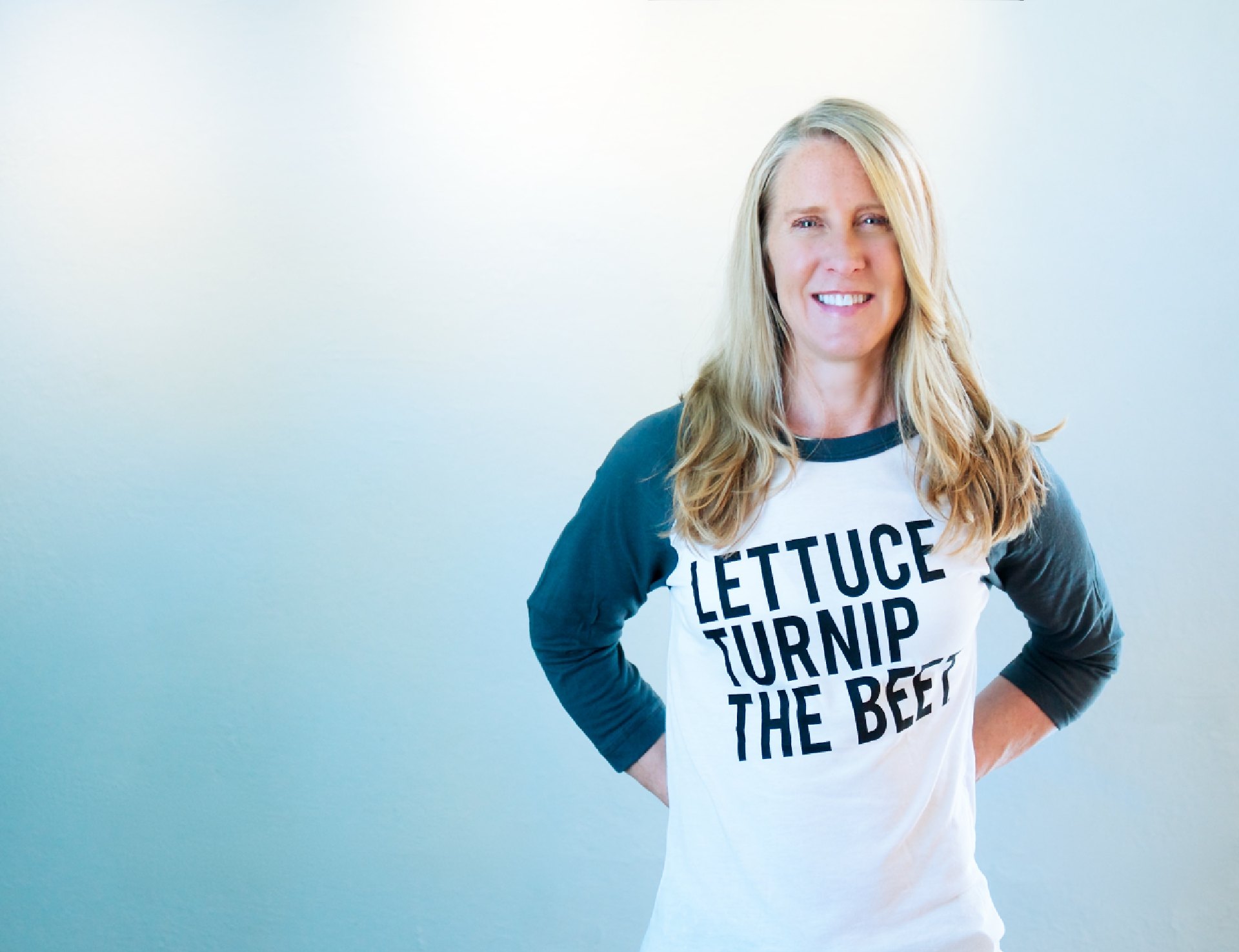 Tanya Mark smiles while wearing a shirt that reads Lettuce Turnip the Beet.