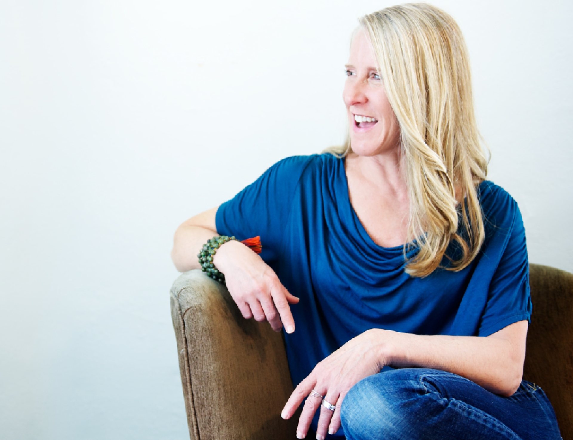 Online nutrition coach Tanya Mark smiles while sitting in a leather chair.