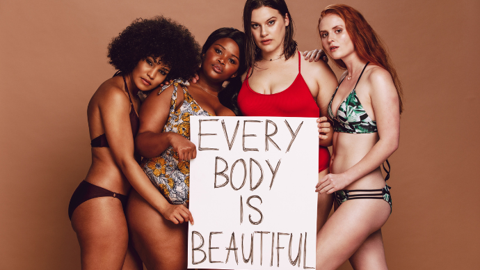 Four diverse woman hold sign reading "Every body is beautiful."